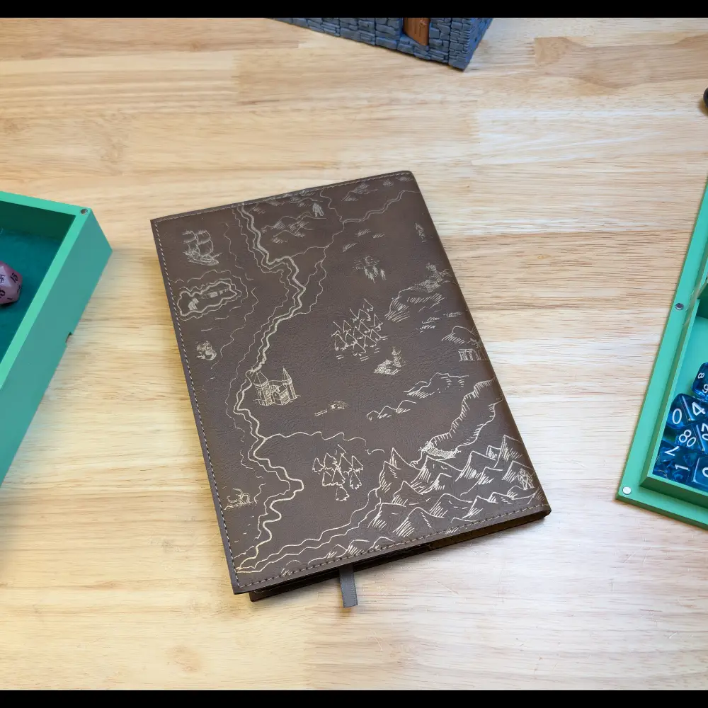 Back cover of laser engraved journal on table with dice and terrain.